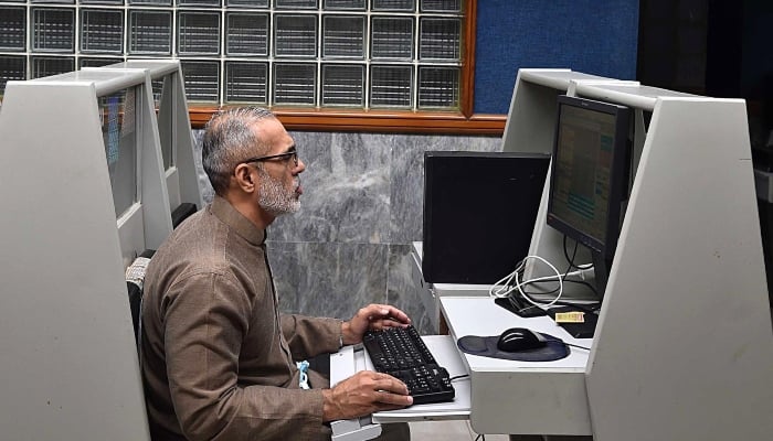 Stockbroker supervises the prices of the actions during a negotiation session in the Pakistan Stock Exchange (PSX) in Karachi, January 21, 2025. - INP