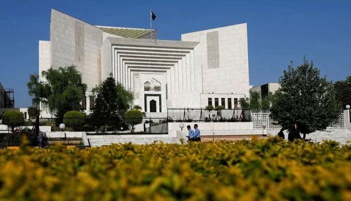 Police officers walk past the Supreme Court building in Islamabad on April 6, 2022. - Reuters