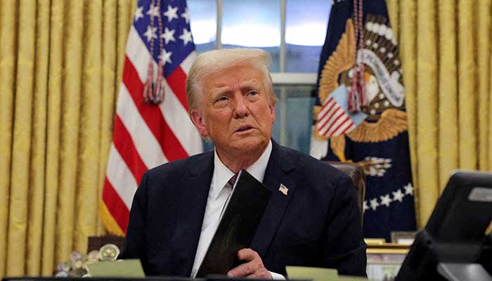 United States President Donald Trump, signs documents while issuing executive and pardoned orders for the defendants of January 6 at the Oval Office of the White House on the day of inauguration in Washington, United States, on the 20th of January 2025. - Reuters