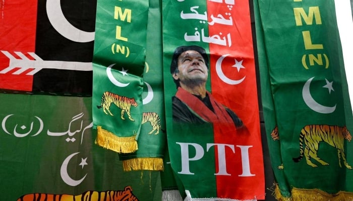 The flags of the political parties are shown for sale in a market in Lahore on January 13, 2024. - AFP