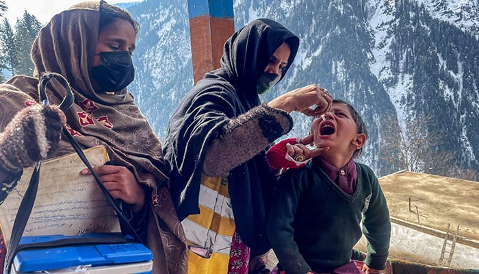 A health worker manages polyomyelitis to a child during a door-to-door vaccination campaign in the middle of strong snow in the Ajks Neelum Valley Bakwali-Surgan area, on February 4, 2025.-AFP