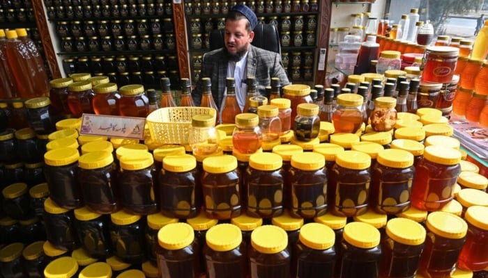 A honey seller awaits the customer market in Chamkanni on the outskirts of Peshawar. - AFP/file