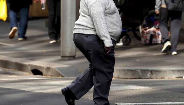 A man crosses a main road while pedestrians walk along the path in the center of Sydney, Australia. - Reuters/file