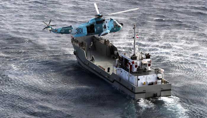 A warship and a helicopter attend a joint naval exercise of Iranian, Chinese and Russian armed in the north of the Indian Ocean on January 20, 2022. - Reuters