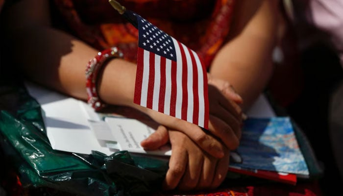 A new American citizen has an American flag during a naturalization ceremony. - Reuters/file