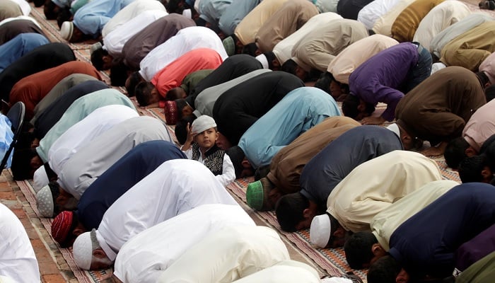 A child sits in the midst of Muslims who perform the prayer of Eid al-Adha in a mosque in Rawalpindi, Pakistan, on September 2, 2017.