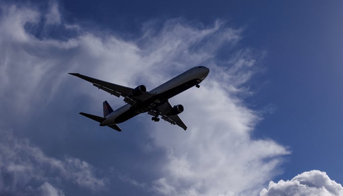 A plane descends the stormy clouds as it approaches the earth, on December 12, 2022. - Reuters