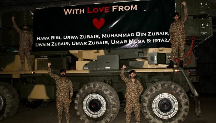 This image without date shows the soldiers of the Pakistan army posing with an armed vehicle decorated with a banner with names of the nastped children by the cowardly missile strikes of the Indies recently. - ISPR