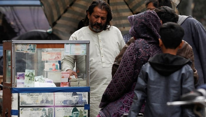 A currency corridor is located near its stand, which is decorated with images of currency notes, while it comes to customers, along a road in Karachi.— Reuters/Archive