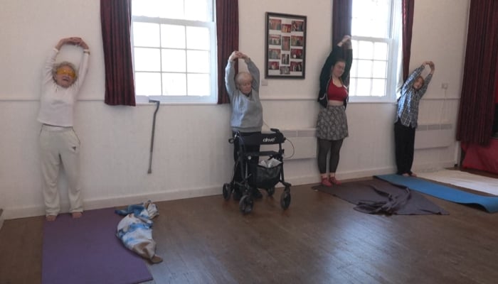 Dorothea Barron (left), with white clothes, teaches yoga. - Screengrab/YouTube/@AFP