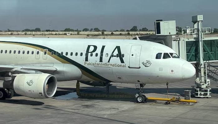 View of the Pakistan International Airlines passenger plane (PIA), carried through a glass panel, at Islamabad International Airport, Pakistan, October 3, 2023. - Reuters