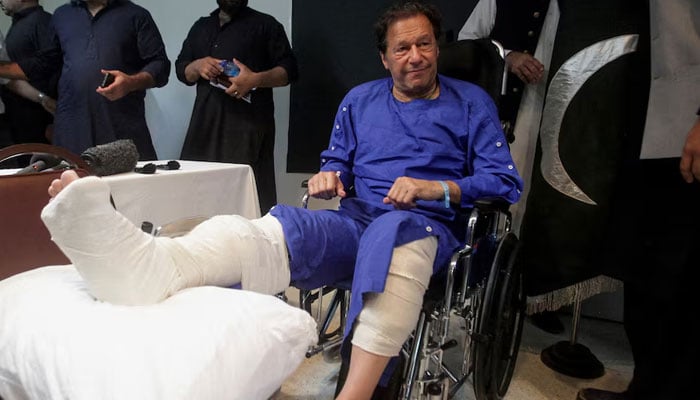 The founder of PTI, Imran Khan, sits in a wheelchair after he was injured after a shooting incident in a long march in Wazirabad, at the Shaukat Khanum Memorial Research and Cancer Research Center in Lahore, November 4, 2022.