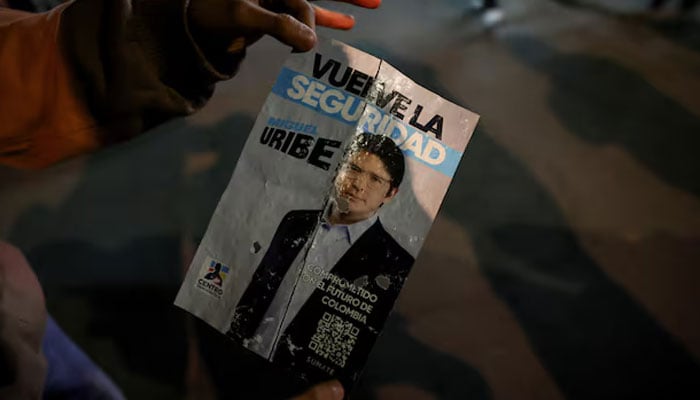 A person has a campaign poster in the area where Colombian senator Miguel Uribe Turbay, from the opposition democratic center party, was shot during a campaign event, in Bogotá, Colombia, on June 7, 2025. - Reuters.