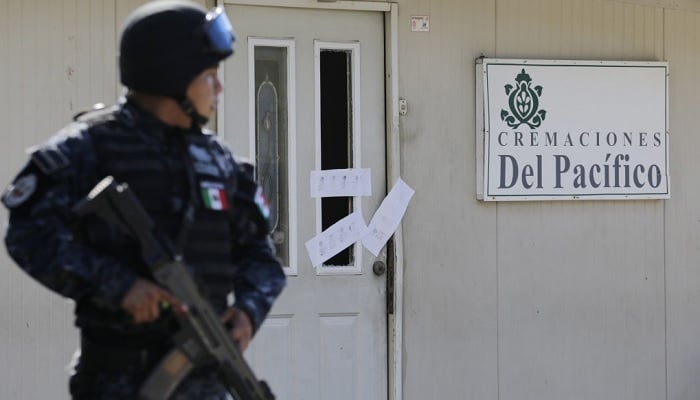 A police officer is stored outside the sealed building that houses a crematorium in Llano Largo, on the outskirts of Acapulco's tourist city. - Reuters/file