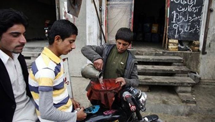 A seller pours Iran's smuggling gasoline on a motorcycle on this image without date. - Reuters/file