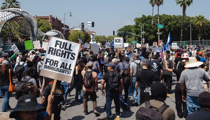 Protesters march through the streets on June 9, 2025 in downtown Los Angeles, California, USA. - AFP