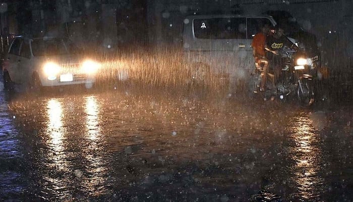 People traveling during heavy rains on June 25, 2023. - Application