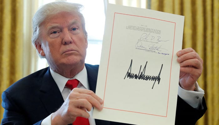 Donald Trump shows his signature after signing the $ 1.5 trillion tax review plan in the Oval Office of the White House in Washington, USA, on December 22, 2017. - Reuters
