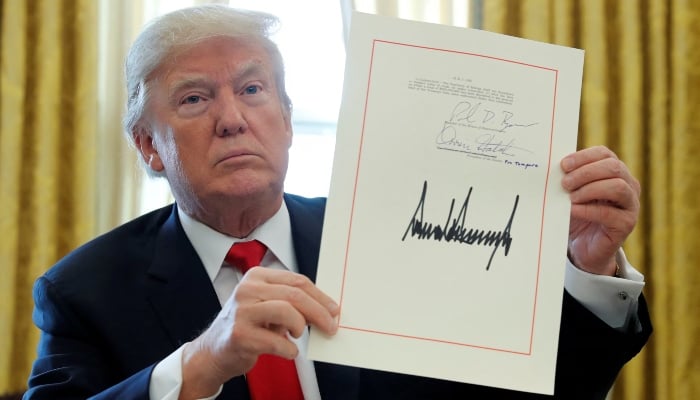 Donald Trump shows his signature after signing the Tax Review Plan of $ 1.5 billion at the Oval Office of the White House in Washington, USA., December 22, 2017. - Reuters