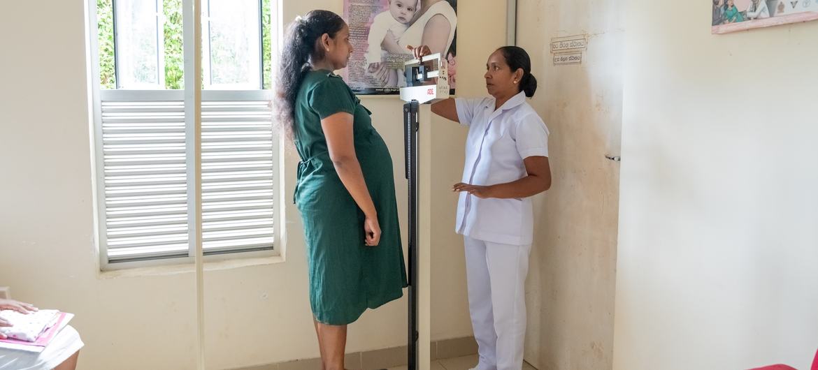 A nurse verifies the weight of a pregnant woman and vital signs in a clinic in Galigamuwa, Sri Lanka. A nurse verifies the weight of a pregnant woman and vital signs in a clinic in Galigamuwa, Sri Lanka.