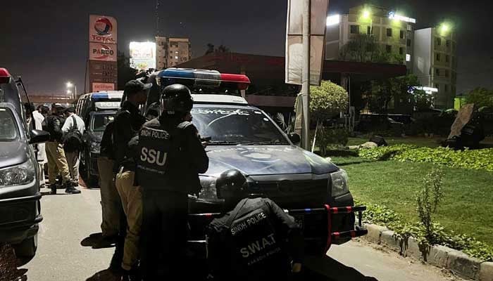 The officers take positions after a police officer building was attacked by armed men in Karachi on February 17, 2023. - Reuters