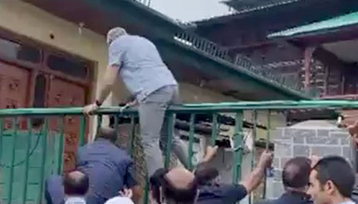 Iiojk cm omar abdullah scales wall to pay tribute in 1931 graveyard of the martyrs in Srinagar on July 14, 2025. - Screengrab through video