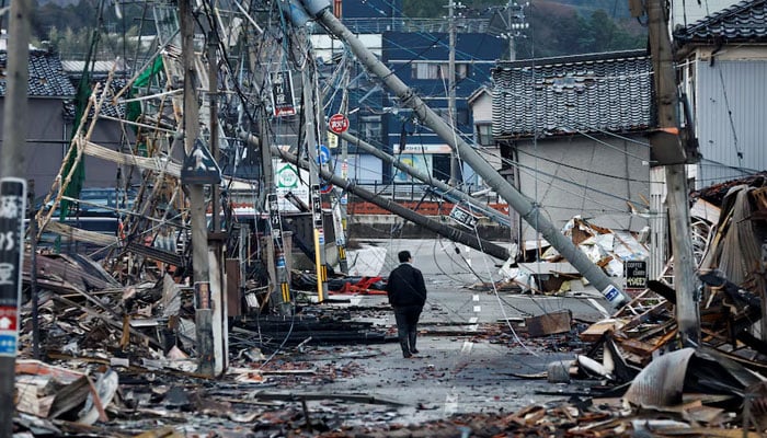 A man makes his way along Asaichi-Ddori street, which caught fire due to a fire after an earthquake, in Wajima, Japan, January 4, 2024.-Reuters