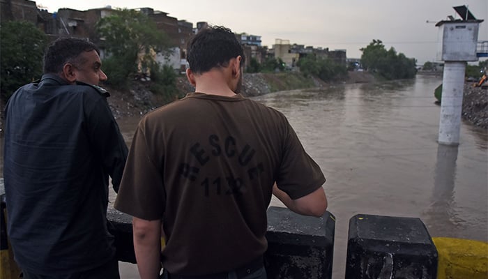 Rescue workers are alert at the water level of the Gawalmandi bridge that increases the increase in Nullah Lai after heavy rawalpindi on July 1, 2025. - Online