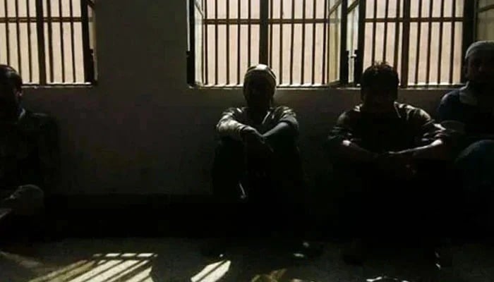 The representative image shows the prisoners sitting inside a dark block. - AFP/file