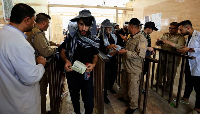 Iraqi border guards verify the Iranian pilgrims who arrive at the border crossing of Zurbatia in September 2022. - Reuters