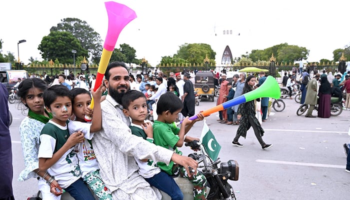A family celebrates Pakistan's independence day near Mazar-E-Qaid in Karachi on August 14, 2024.-Epp