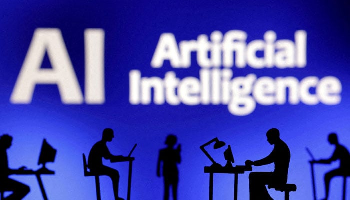 The figures with computers and smartphones are seen in front of the words artificial intelligence AI in this illustration taken, February 19, 2024. - Reuters