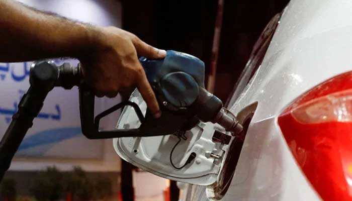 A worker has a fuel nozzle to fill fuel in a car at the gasoline station in Karachi, on September 16, 2023. - Reuters