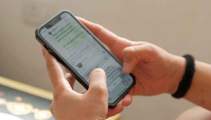 This representation image shows a person by sending text messages through WhatsApp. - Unspash
