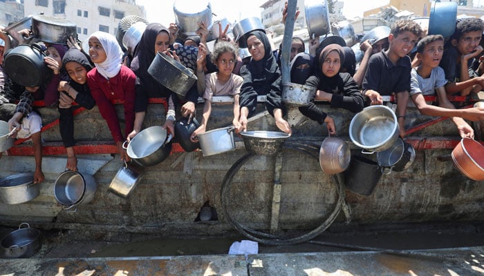 The Palestinians wait to receive food from a charity kitchen, in the midst of a hunger crisis, in the city of Gaza, on August 2, 2025. - Reuters