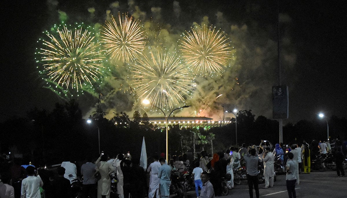 People look at artificial fires exploiting during the celebration of Independence Day in Islamabad on August 14, 2025. - Reuters