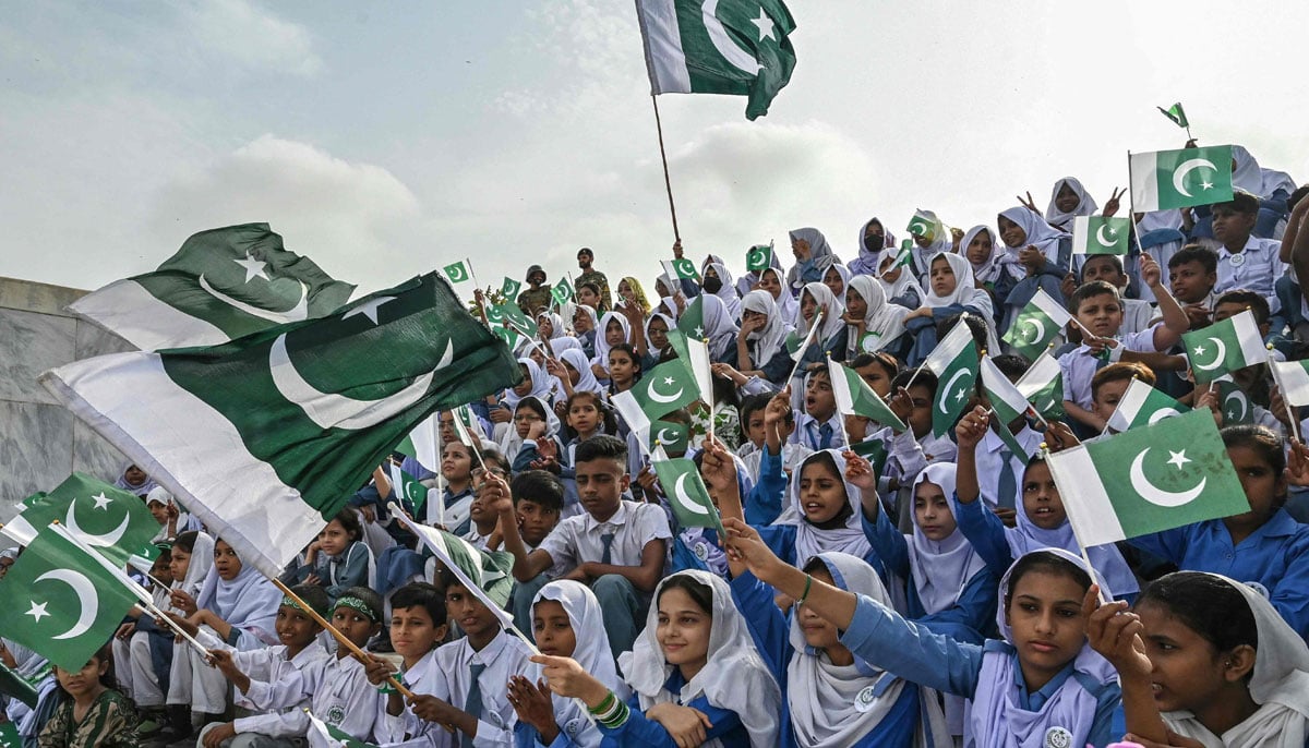 Students greet national flags during the celebrations of Independence Day in the Mausoleo de Muhammad Ali Jinnaah, in Karachi on August 14, 2025. - AFP