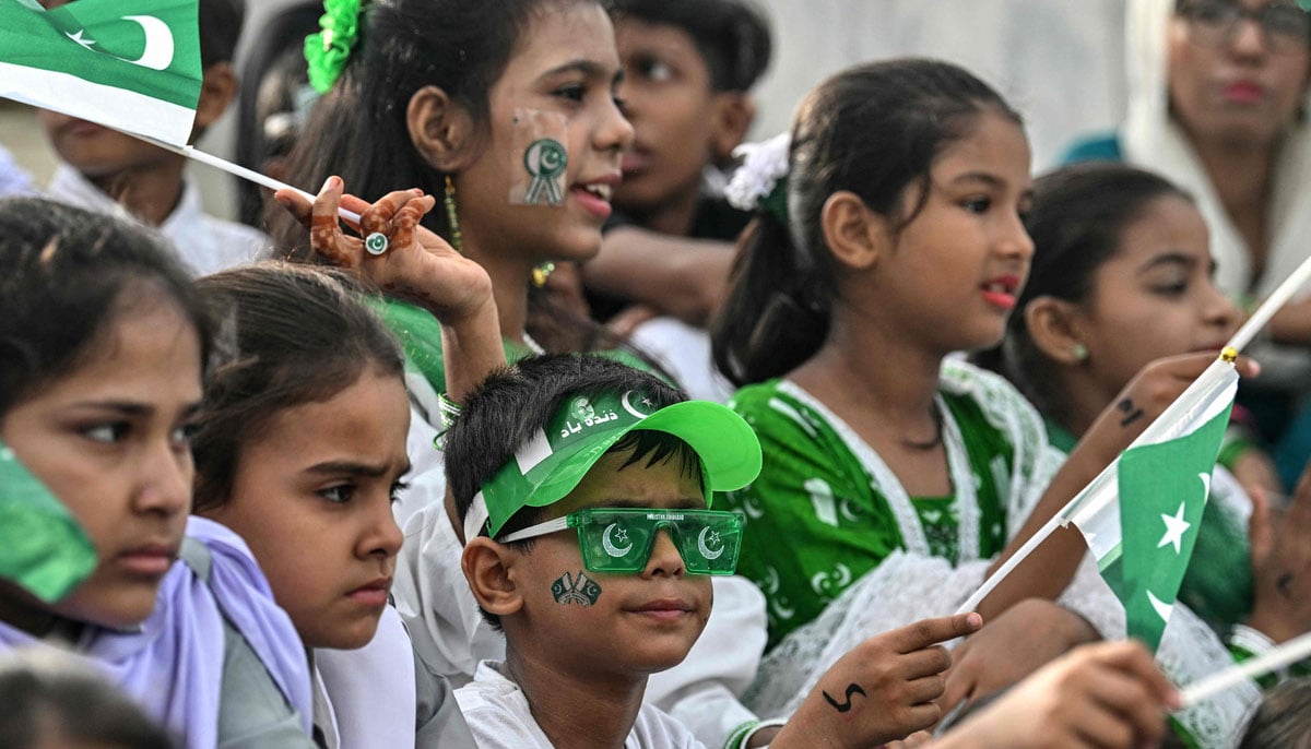 Students greet national flags during the celebrations of Independence Day in the Mausoleo de Muhammad Ali Jinnaah, in Karachi on August 14, 2025. - AFP