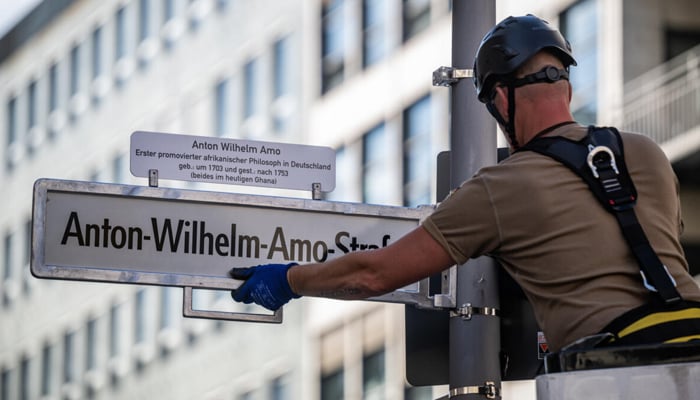 A worker installs a sign with the new name of the streets, after years of controversy and a drama of the last minute court on the old name, Mours Street. - AFP