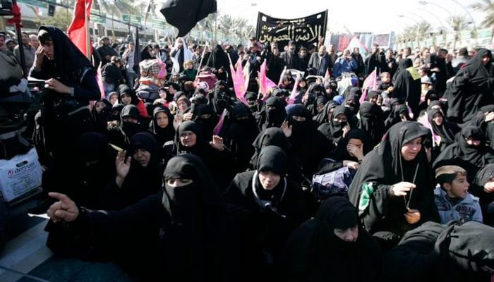 The pilgrims participate in a ceremony to mark the religious ritual of Arbaeen in Kerbala, about 80 km (50 miles) southwest of Baghdad, December 24, 2013. - Reuters