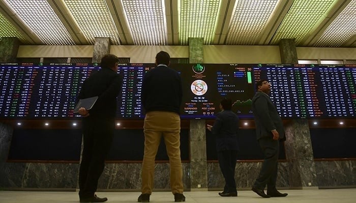 The runners monitor an index board that shows the latest prices of shares in the Pakistan Stock Exchange in Karachi on January 26, 2023. - AFP