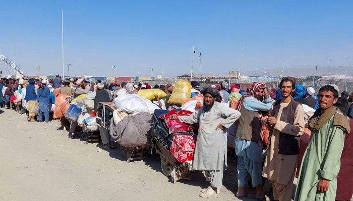 Afghan citizens wait with their belongings to cross Afghanistan, at the Friendship Gate of the Chaman border crossing along the border between Pakistan-Fganistan in Baluchistan, in Chaman, on October 31, 2023.-Reuters