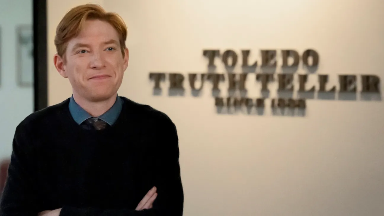 Domnhall Gleeson stops a signal for the Toledo Truth Teller newspaper