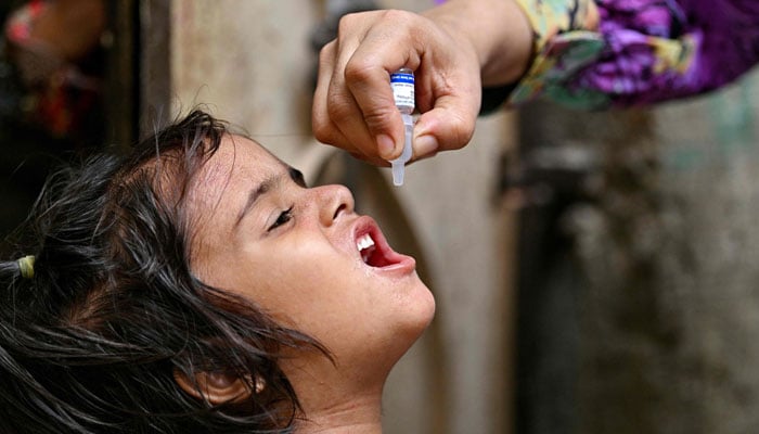 A health worker manages polyomyelitis to a child for vaccination on the first day of a national poliovirus eradication campaign of a week in Karachi on May 26, 2025.-AFP