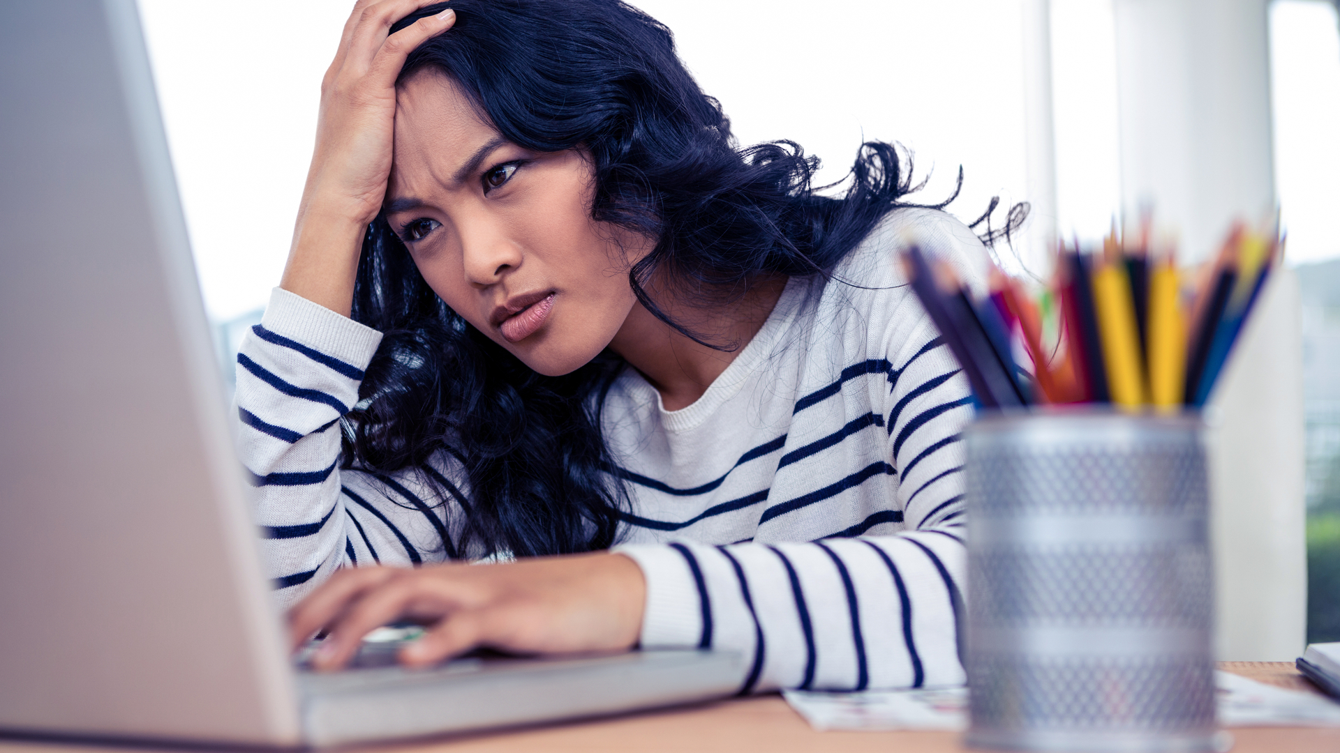 A woman who looks perplexed on her Windows 11 laptop
