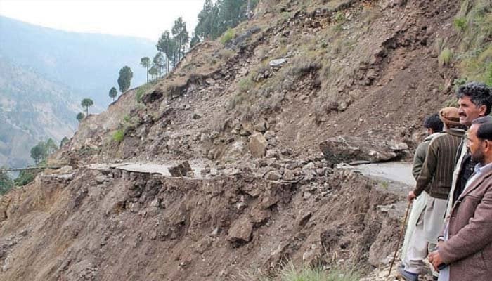 This image without date shows people stops near a landslide site in an unleashed place. - GEO TV/File