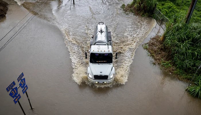A truck drives through a flooded road when the hurricane of category 3 Erin leaves the region in Naguabo, Puerto Rico, on August 16, 2025.