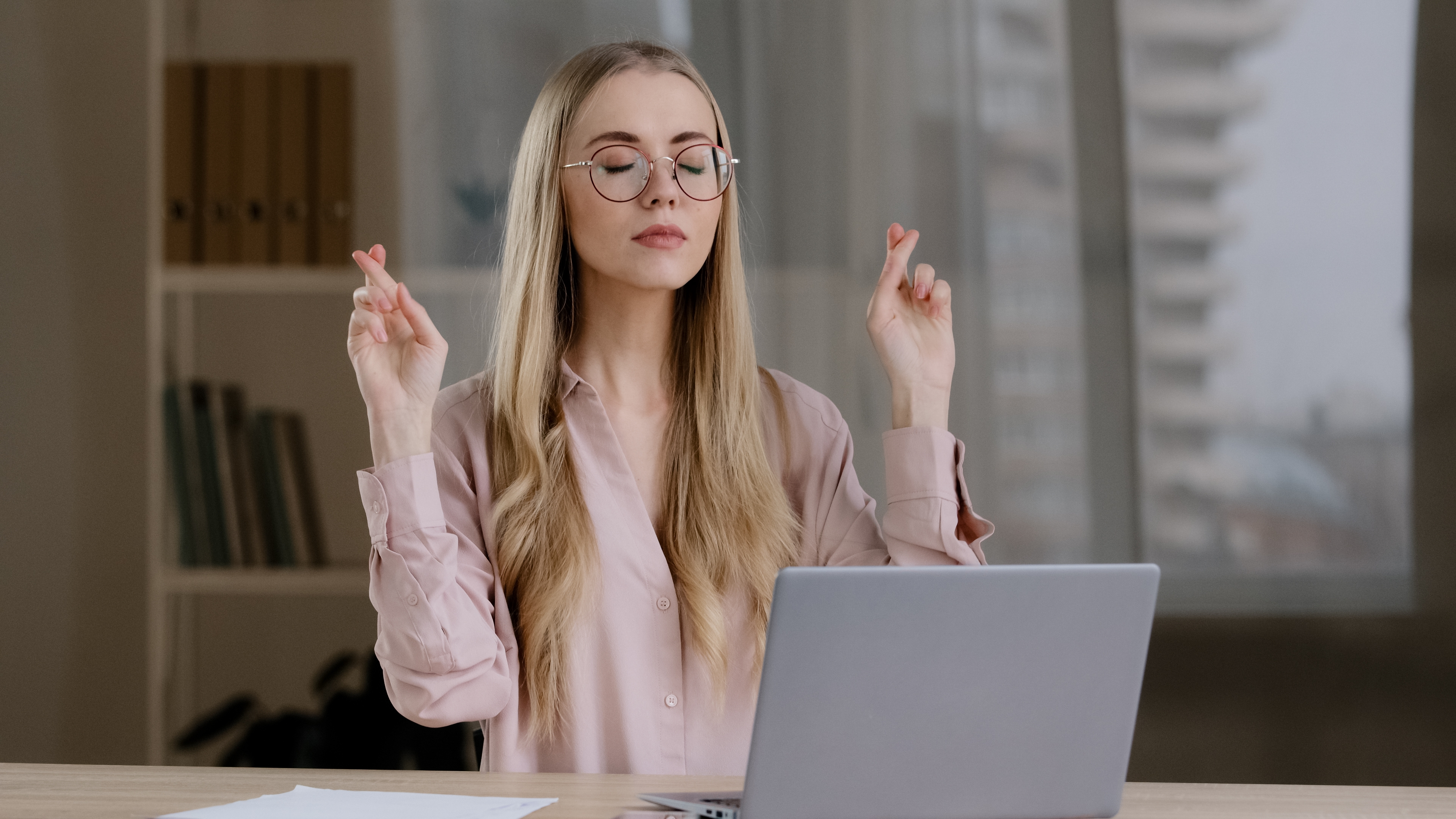 Girl who uses the laptop waiting for good luck with cross fingers