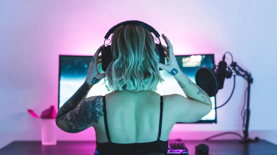 A player with headphones sat on a monitor on a desktop