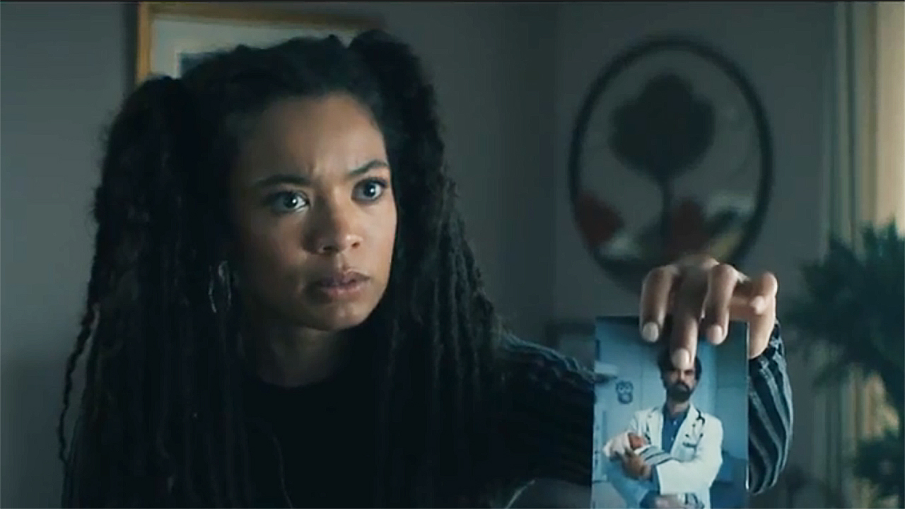 A surprised Marie holding a photo of Cipher/Doctor Gould in Generation V of season 2 Episode 3